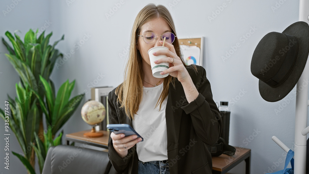 A young woman sips coffee while checking her smartphone in a casually professional office environment, embodying modern work life. A young woman sips coffee while checking her smartphone in a casually professional office environment, embodying modern work life.