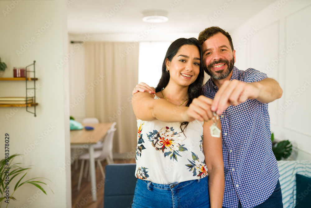 New home, new beginnings: a happy couple showing off keys in their cozy living room, ready to start a life together in their dream home New home, new beginnings: a happy couple showing off keys in their cozy living room, ready to start a life together in their dream home