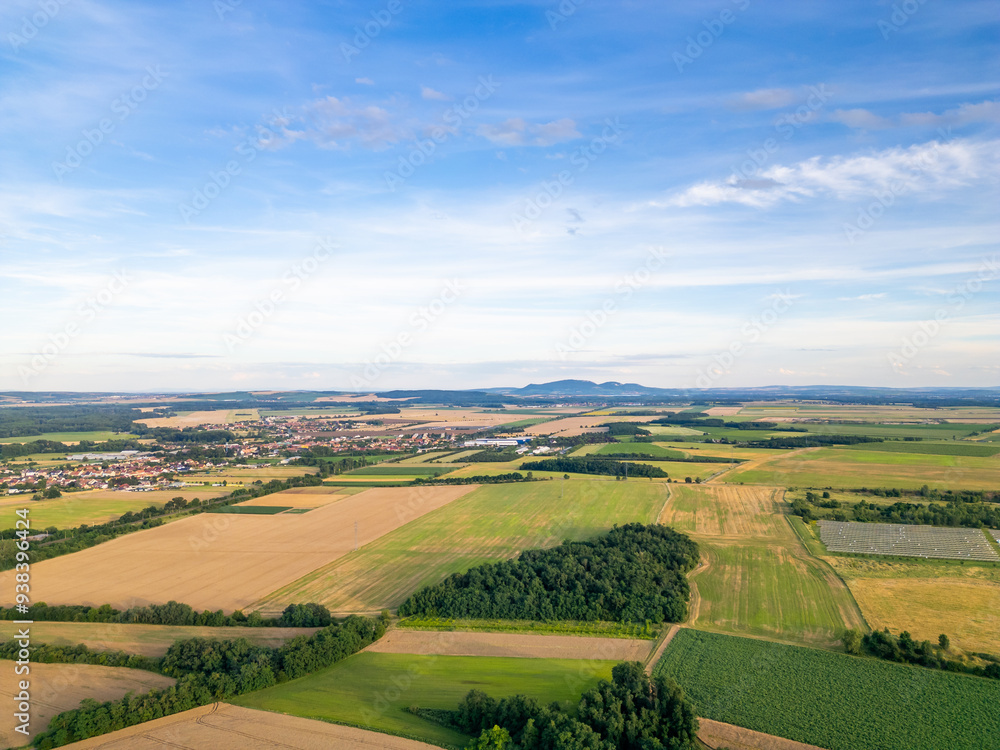 A stunning drone view of Hrusovany u Brna, showcasing the charming town, surrounding vineyards, and a distant, scenic view of the Palava Hills.