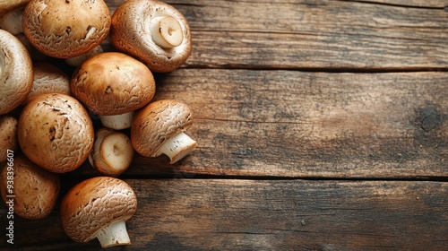 Fresh mushrooms arranged on rustic wooden table with decorative herbs