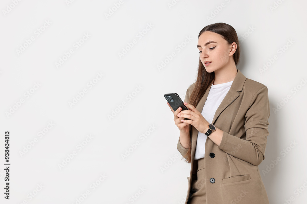 Woman in beige suit using smartphone on white background, space for text Woman in beige suit using smartphone on white background, space for text
