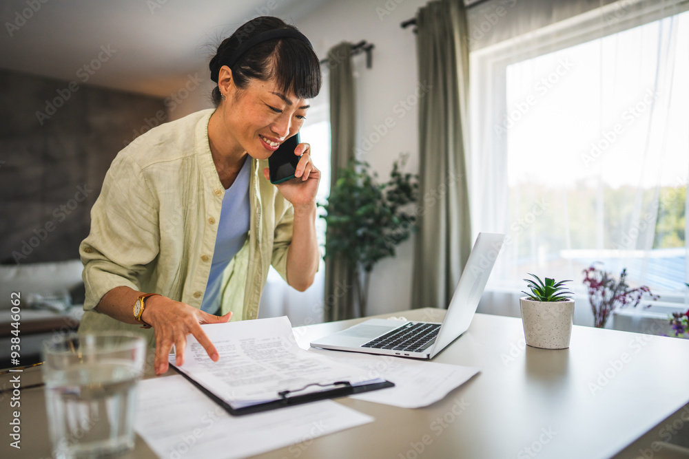 Japanese woman with work from home on laptop and talk on mobile phone Japanese woman with work from home on laptop and talk on mobile phone