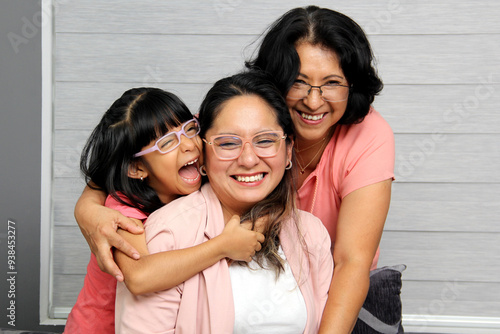 Brunette Latina grandmother, mom and daughter with glasses show their love and support to celebrate Mother's Day photo