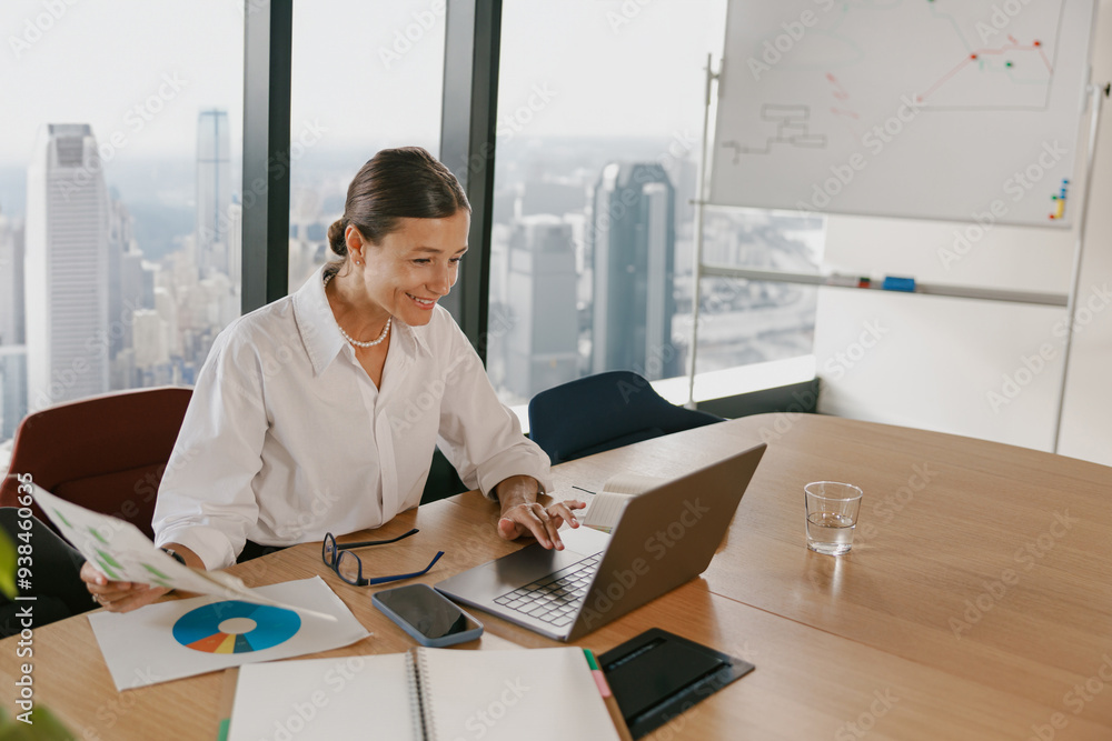 A professional businesswoman is diligently analyzing data within a modern office environment A professional businesswoman is diligently analyzing data within a modern office environment