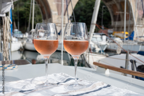 Party with rose wine on yacht boat anchored in port la Rague, Gulf of La Napoule, in Provence, two glasses of cold rose wine, French Riviera near Cannes, south of France photo