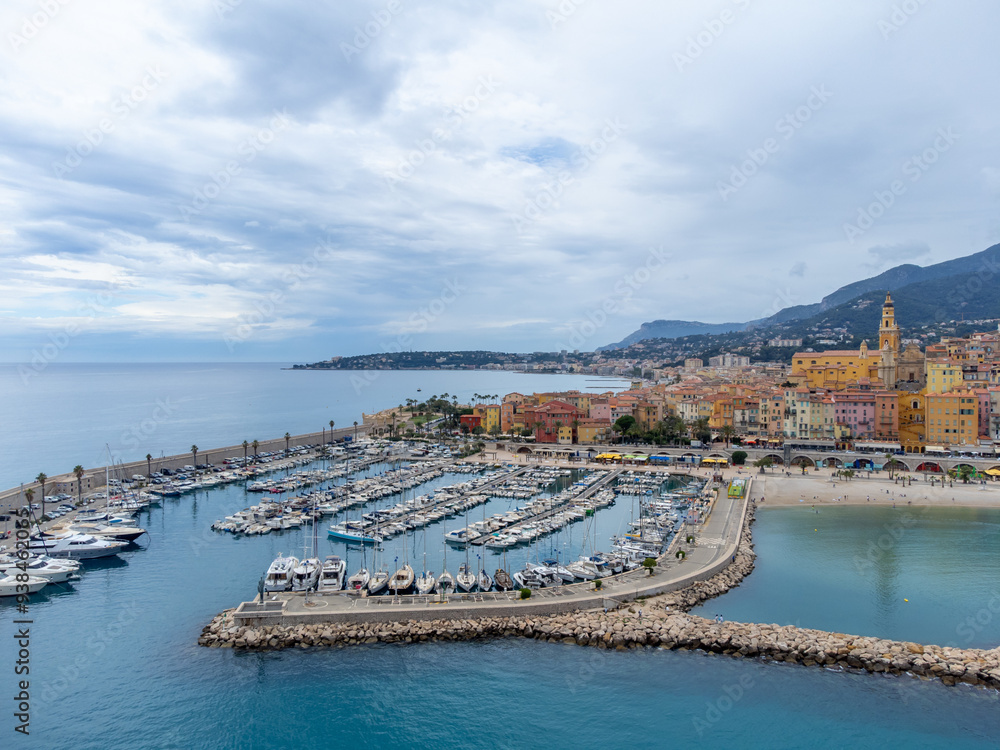 Naklejka premium Aerial view on French Riviera, colorful Menton old city and marina on Mediterranean Sea near French-Italian border, travel destination, panoramic view from above