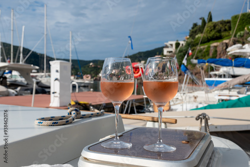 Party with rose wine on yacht boat anchored in port la Rague, Gulf of La Napoule, in Provence, two glasses of cold rose wine, French Riviera near Cannes, south of France photo