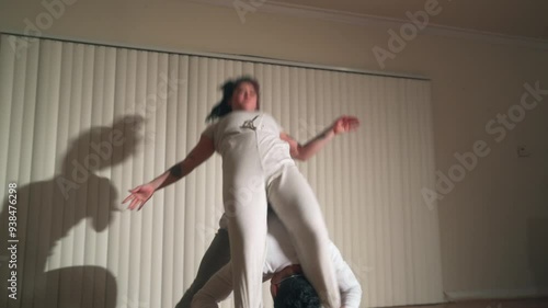 A couple do a acrobatic dance move together