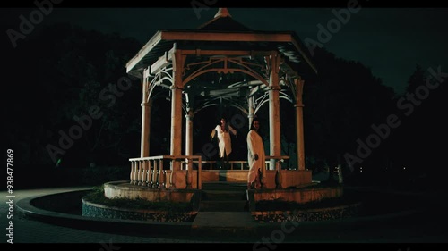 Woman walks to the right and levitates in the background