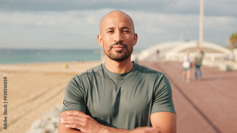 Portrait of confident male athlete against blured background of the sea and sky with arms crossed on his chests Portrait of confident male athlete against blured background of the sea and sky with arms crossed on his chests