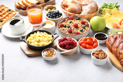 Tasty breakfast. Many different food and drinks on grey textured table