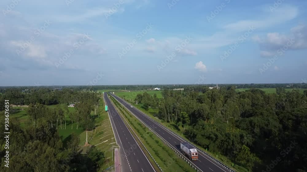 drone shot video of a national highway with vehicles in motion constructed between lush green farmland in a village in India drone shot video of a national highway with vehicles in motion constructed between lush green farmland in a village in India