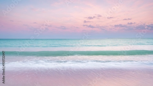 Serene ocean waves gently lapping against a tranquil beach under a pastel-hued sunset sky. Calming seascape with soft, pink and blue colors, perfect for relaxation and peaceful nature themes.