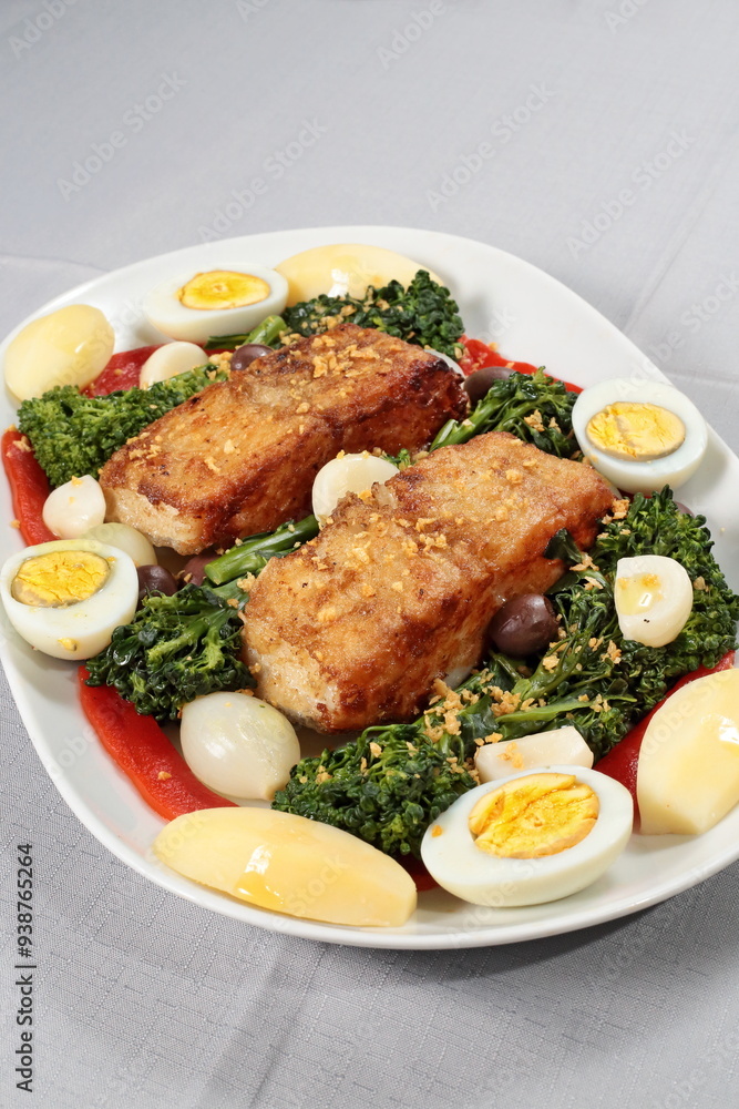 Portuguese cod with eggs, broccoli and peppers on a plate Portuguese cod with eggs, broccoli and peppers on a plate