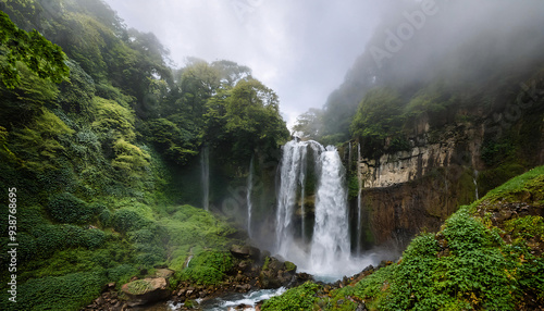 A turbulent waterfall cascading down a rocky cliff,