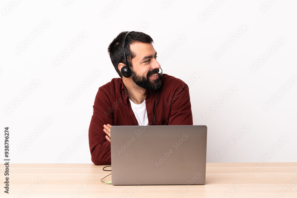 Telemarketer caucasian man working with a headset and with laptop with arms crossed and happy. Telemarketer caucasian man working with a headset and with laptop with arms crossed and happy.