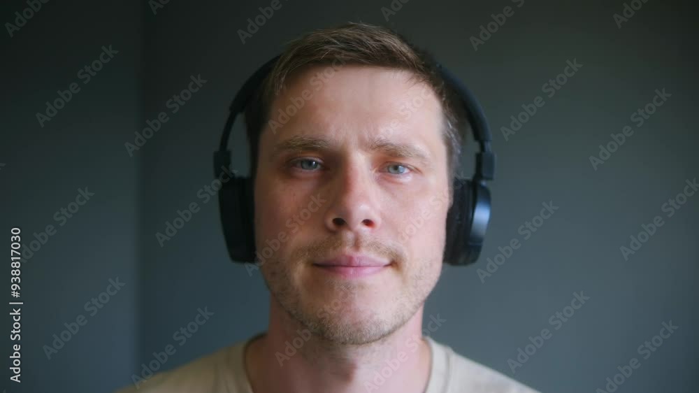 Young man in headphones exudes sense of calm and satisfaction. Guy fully immerses in rhythm and melody playing in home environment Young man in headphones exudes sense of calm and satisfaction. Guy fully immerses in rhythm and melody playing in home environment