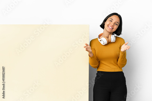 Young woman listening music with a big empty placard over isolated background presenting and inviting to come with hand photo