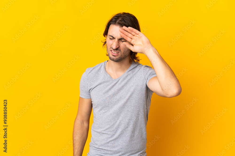 Young handsome man isolated on yellow background with tired and sick expression Young handsome man isolated on yellow background with tired and sick expression