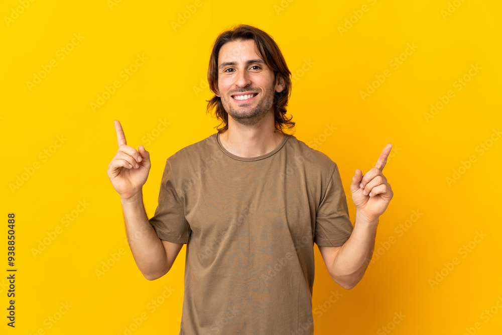Young handsome man isolated on yellow background pointing up a great idea Young handsome man isolated on yellow background pointing up a great idea