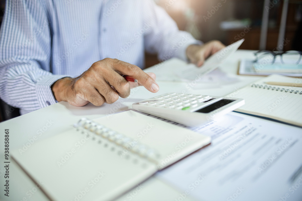 Close-up shot. asian men hand using calculator to calculate expenses and tax to recive tax reduction for personal individual Income. tax return concept for individual person Close-up shot. asian men hand using calculator to calculate expenses and tax to recive tax reduction for personal individual Income. tax return concept for individual person