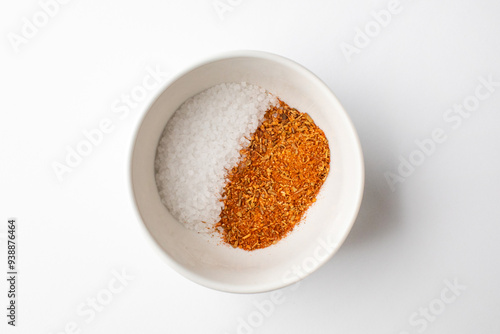 A white bowl containing an equal mix of salt and red spices, representing balance in cooking ingredients and flavors