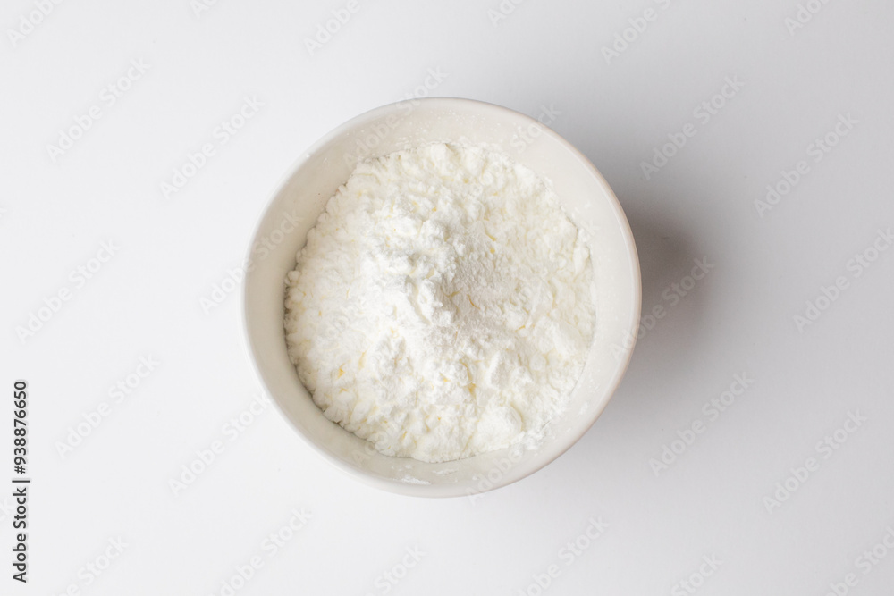 White powder in a bowl, zoomed in on a white background, commonly used for baking during Christmas holidays White powder in a bowl, zoomed in on a white background, commonly used for baking during Christmas holidays