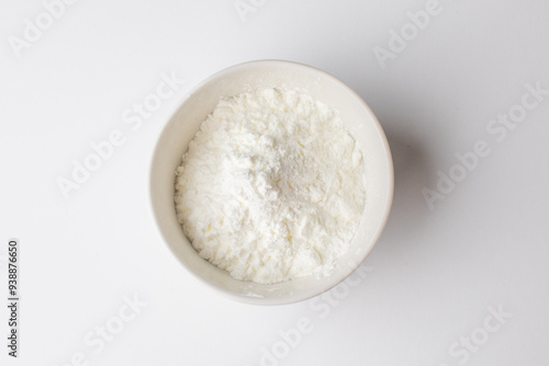 White powder in a bowl, zoomed in on a white background, commonly used for baking during Christmas holidays