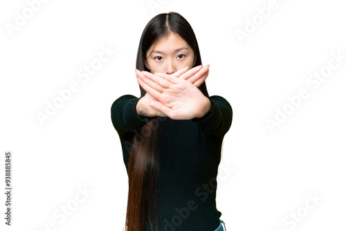 Young Asian woman over isolated chroma key background making stop gesture with her hand to stop an act photo