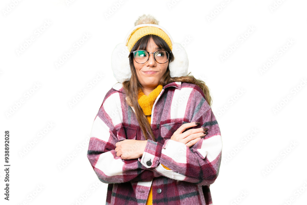 Young caucasian woman wearing winter muffs over isolated chroma key background making doubts gesture while lifting the shoulders Young caucasian woman wearing winter muffs over isolated chroma key background making doubts gesture while lifting the shoulders