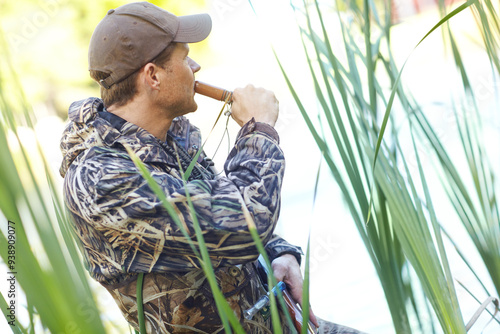 Canvas Print Hunter, man and duck whistle outdoor for camouflage, hunting wildlife and adventure activity of bird calling