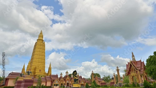 Stunning scene of fast motion clouds with blue sky over beautiful buddhist monastery. Time lapse of great golden pagoda in the temple with unrecognised peoples. Wat Bang Thong, Krabi, Thailand photo