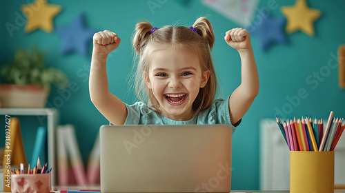 High-resolution photo of a happy little girl celebrating with her laptop in the study room. photo