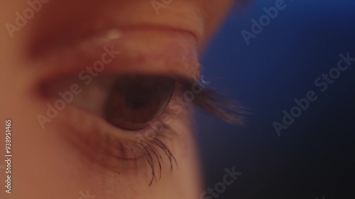 Close-up of an eye. Macro plan. Warm color. Orange and blue. Girl reading a book, Close-up of eyes. Shifty eyes. Brown big eyes photo