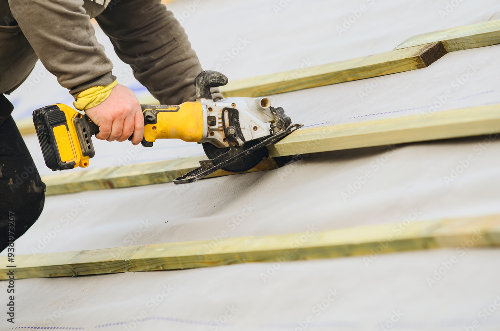 Worker Using Circular Saw to Cut Wooden Beams at Construction Site During Daylight Hours Worker Using Circular Saw to Cut Wooden Beams at Construction Site During Daylight Hours