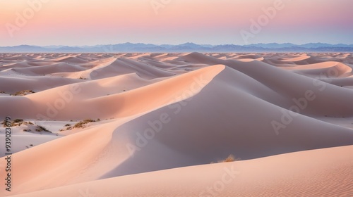 A serene desert landscape with endless rolling dunes under a pastel-colored sky. Soft sand hues of peach and pink create a tranquil, dreamlike atmosphere. Mountains in the background add depth.