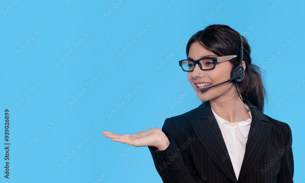Professional Woman With Headset Offering Assistance Against a Solid Blue Background Professional Woman With Headset Offering Assistance Against a Solid Blue Background
