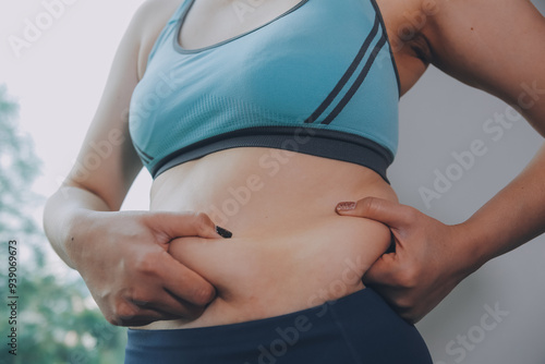 fat woman, fat belly, chubby, obese woman hand holding excessive belly fat with measure tape, woman diet lifestyle concept