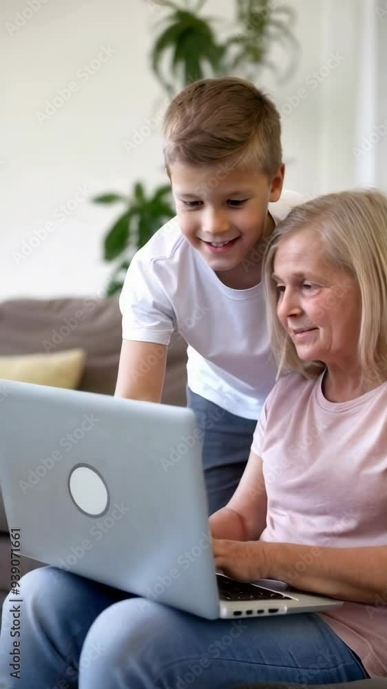 Grandson assists his grandmother in using a laptop in the living room. Grandson assists his grandmother in using a laptop in the living room.