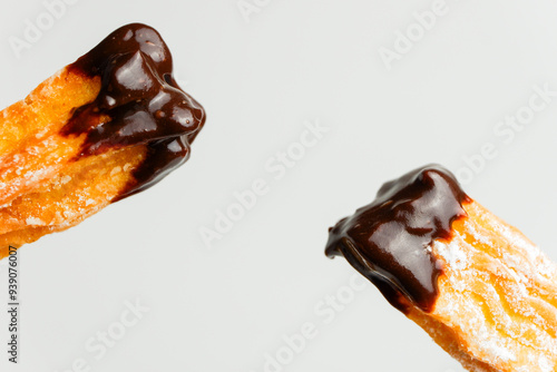 churros dipped on chocolate with sugar powder sprinkles