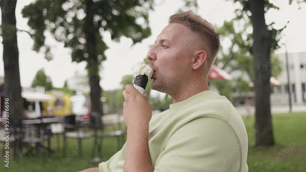 Young Caucasian 30s man smiling happy eating ice cream cone at the city park. High quality FullHD footage Young Caucasian 30s man smiling happy eating ice cream cone at the city park. High quality FullHD footage