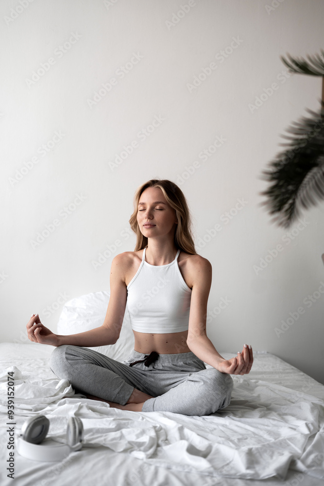 Cute woman in lotus pose on bed practicing yoga at home. Concept lifestyle. Cute woman in lotus pose on bed practicing yoga at home. Concept lifestyle.
