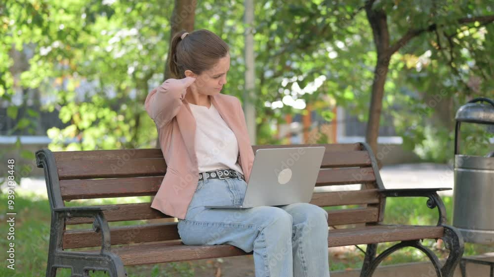 Tired Young Woman with Neck Pain Using Laptop in Park Tired Young Woman with Neck Pain Using Laptop in Park