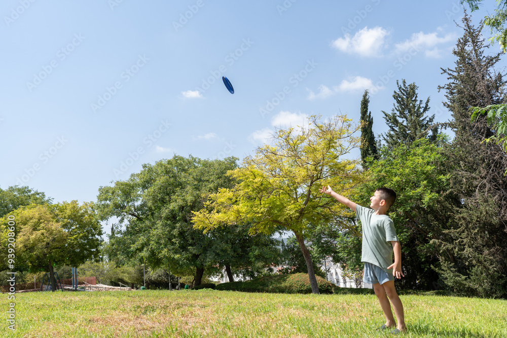 Young child throws a frisbee high into the sky in a park. Capturing a moment of joy and physical activity in a natural outdoor setting. Young child throws a frisbee high into the sky in a park. Capturing a moment of joy and physical activity in a natural outdoor setting.