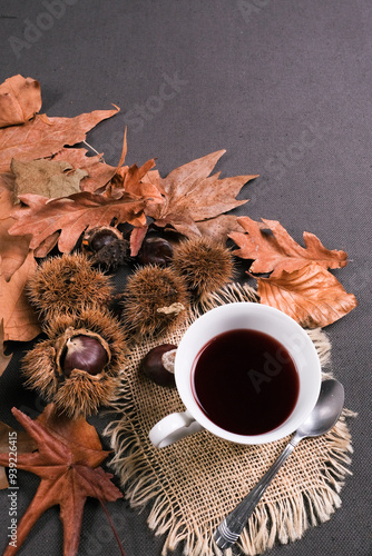 Tazzina di caffè sul tavolo con foglie secche e ricci di castagne, autunno, spazio per testo photo