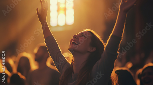 Young woman in a crowded church raising her hands in worship with joyful expression under warm sunlight streaming through a stained glass window, copy space