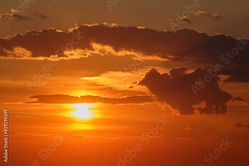 Sunset with dramatic clouds in orange sky. Nature photography. Twilight sky landscape for design and print.