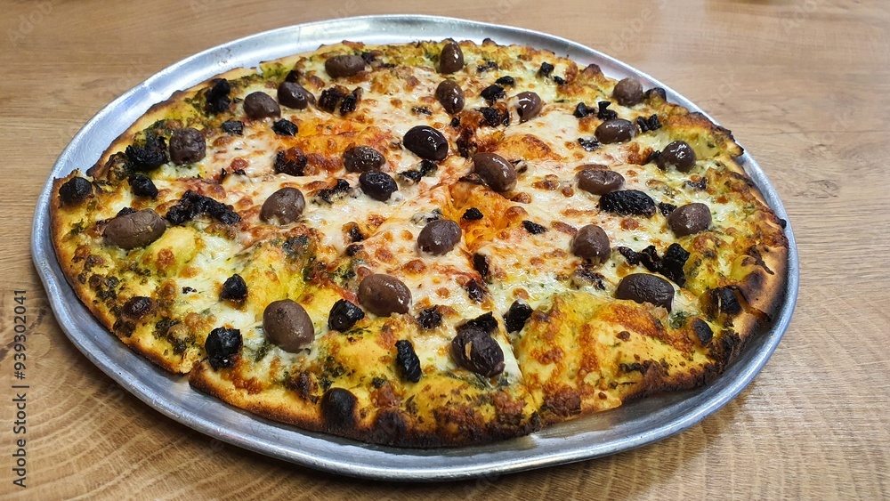 Whole Pizza with Cheese, Whole Black and Brown Olives, and Tomato Sauce on Round Tray on Wooden Table Whole Pizza with Cheese, Whole Black and Brown Olives, and Tomato Sauce on Round Tray on Wooden Table