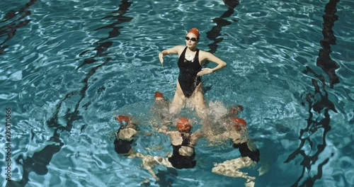 Swimmer launching a girl outside of water during practice