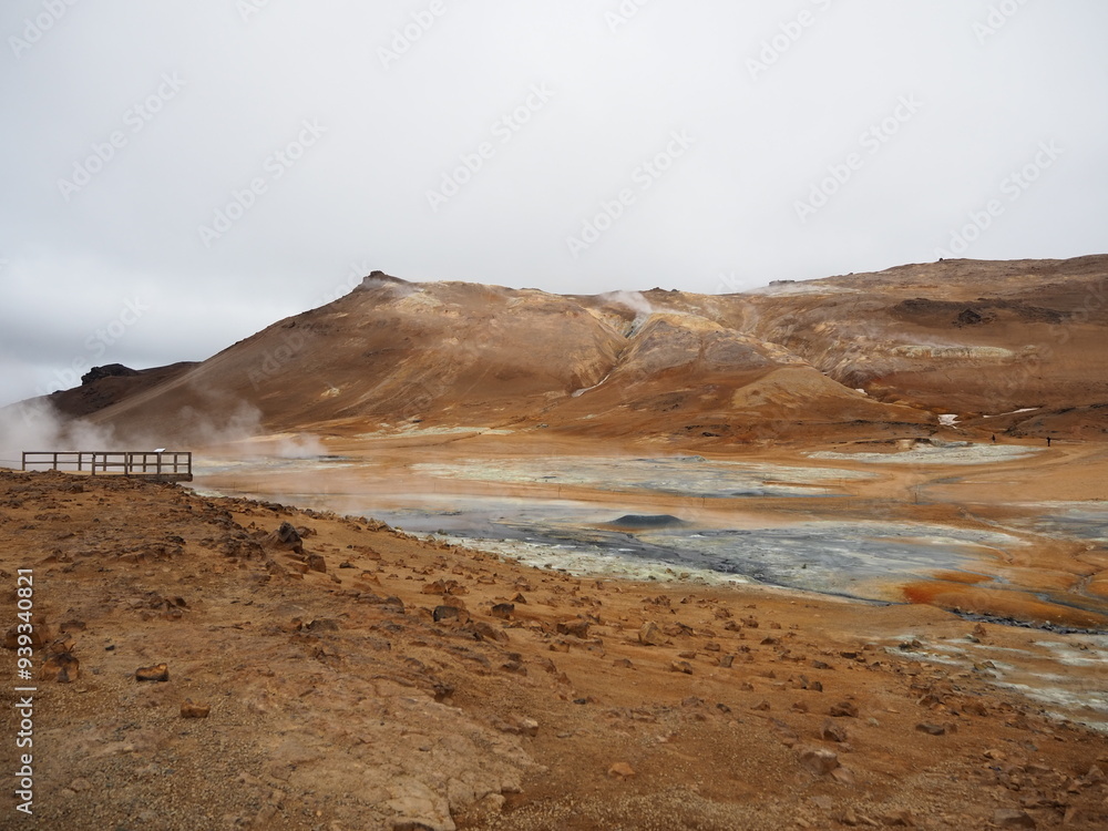 A barren geothermal landscape with steaming vents and surrounding hills creates an otherworldly and captivating scene, showcasing the raw, untamed beauty and power of geothermal activity. A barren geothermal landscape with steaming vents and surrounding hills creates an otherworldly and captivating scene, showcasing the raw, untamed beauty and power of geothermal activity.